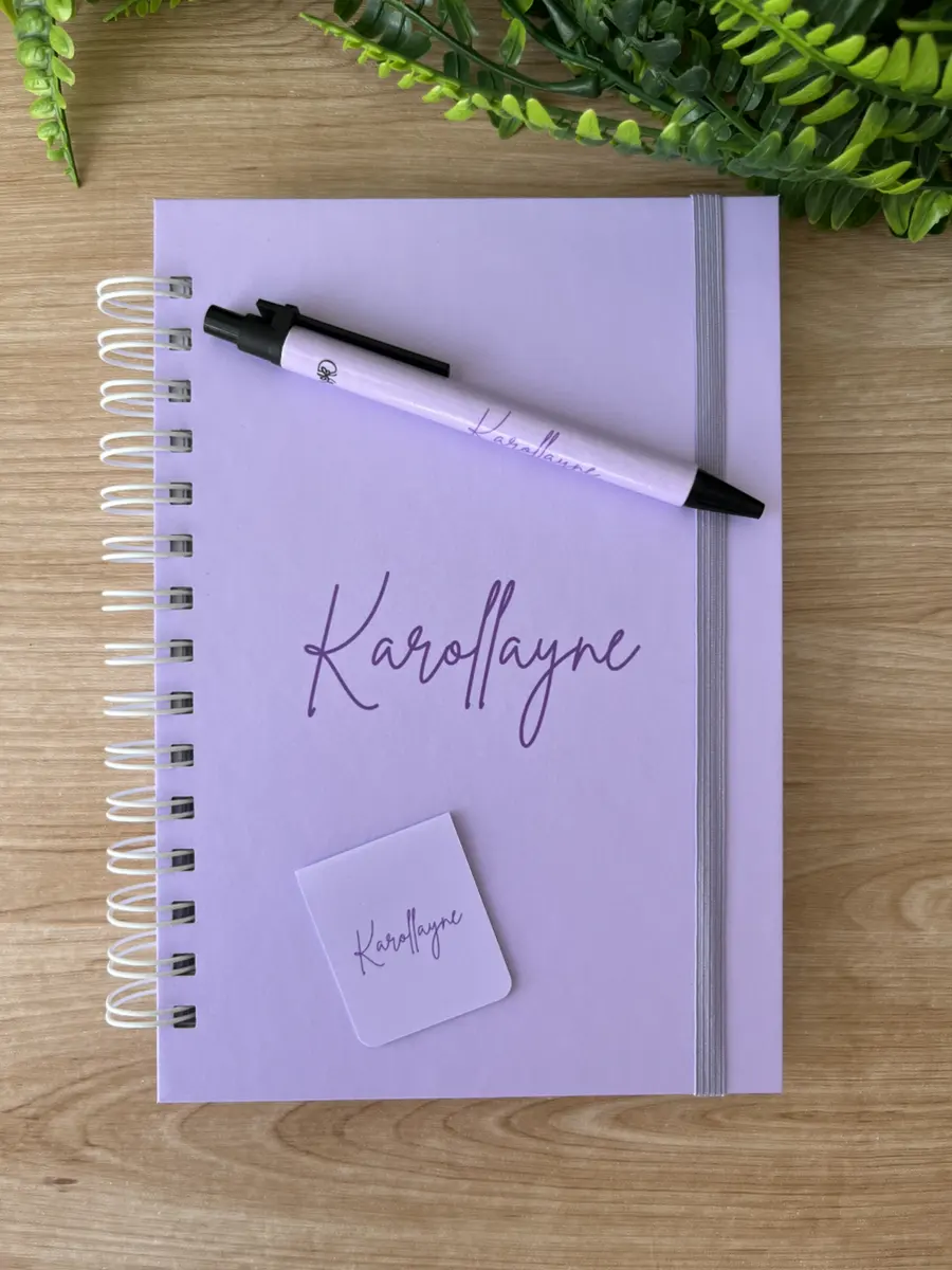 Caderno lilás com nome e caneta